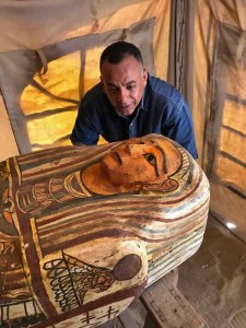 This Sept. 2020 photo provided by the Ministry of Tourism and Antiquities shows Mostafa Waziri, secretary general of the Supreme Council of Antiquities, posing with one of more than two dozen ancient coffins unearthed near the famed Step Pyramid of Djoser in Saqqara, south of Cairo, Egypt. (Ministry of Tourism and Antiquities via AP)