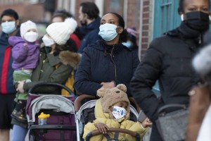 Makda Yesuf, center, and her son Jaden wait in line at a COVID-19 walk-in testing site, Dec. 5, 2021, in Cambridge, Mass. Even as the U.S. reaches a COVID-19 milestone of roughly 200 million fully vaccinated people, infections and hospitalizations are spiking, including in highly vaccinated pockets of the country like New England. (AP Photo/Michael Dwyer, File)
