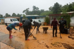 People clean debris from a road after a mudslide caused by Hurricane Fiona in Cayey, Puerto Rico, Sunday, September 18, 2022. (AP Photo/Stephanie Rojas)