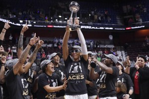 Las Vegas Aces' A'ja Wilson holds up the championship trophy as she celebrates with her team their win in the WNBA basketball finals against the Connecticut Sun, Sunday, Sept. 18, 2022, in Uncasville, Conn. Photo by Jessica Hill - Photojournalist