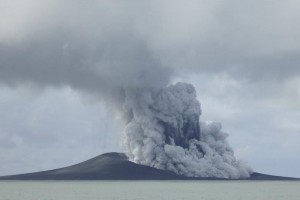 The Tonga Volcano explodes releasing a cloud of water vapor that looks like grey smoke.
